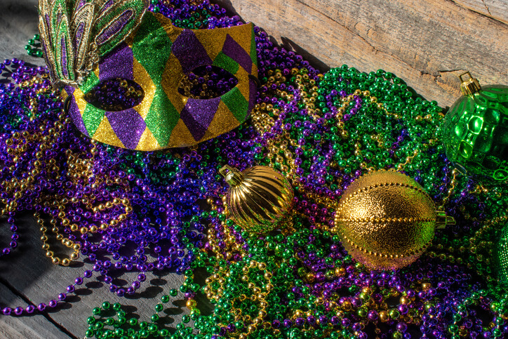 Fun Weekend Trip in Your State: Mardi Gras decorations with pile of beads, mask, and ornaments