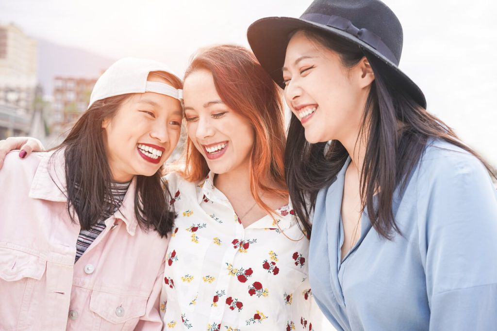 Most Powerful Passports: Asian women friends having fun outdoor in a sunny day