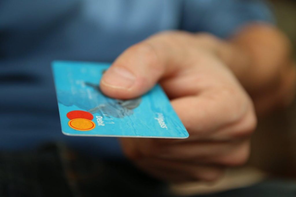 points vs miles: Person Holding Debit Card